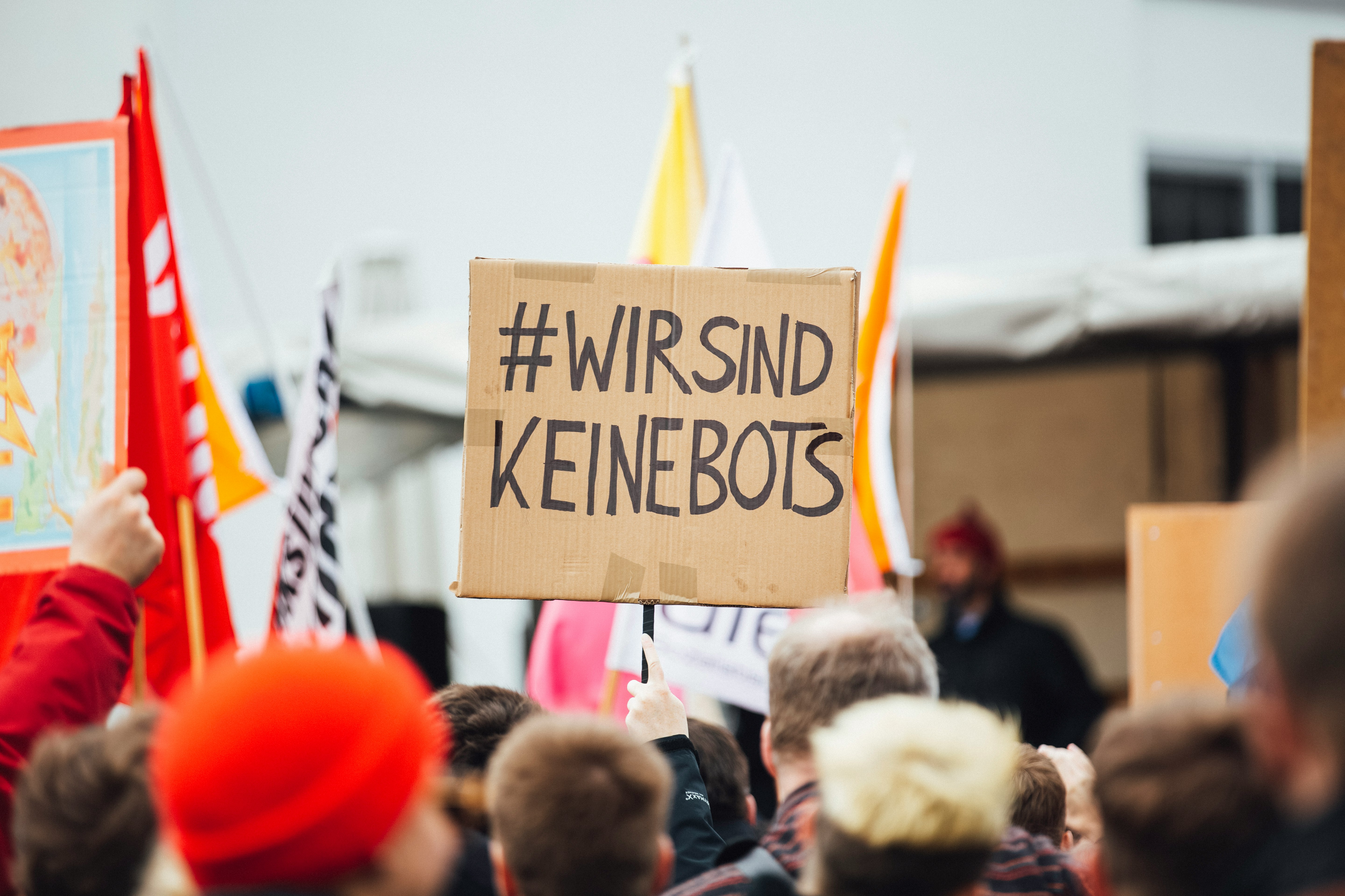 person raising wirsind keinebots signboard